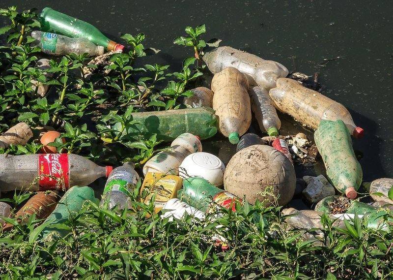 břeh znečištěný plastovými láhvemi a odpadem